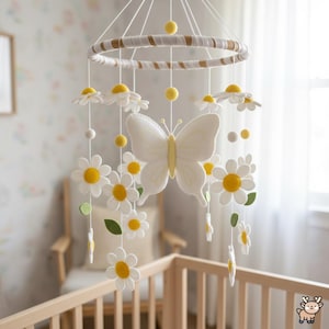 May include: A hanging nursery mobile featuring a central white butterfly with yellow accents, surrounded by multiple white daisy flowers with yellow centers and small green leaves, all suspended from a circular hoop wrapped in white and tan fabric.
