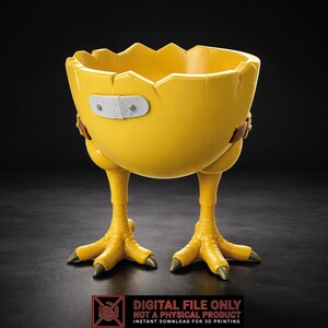 Puede incluir: Un recipiente amarillo en forma de cáscara de huevo con patas de pollo. La cáscara tiene una parte superior dentada y una venda blanca. Un objeto decorativo y divertido.
