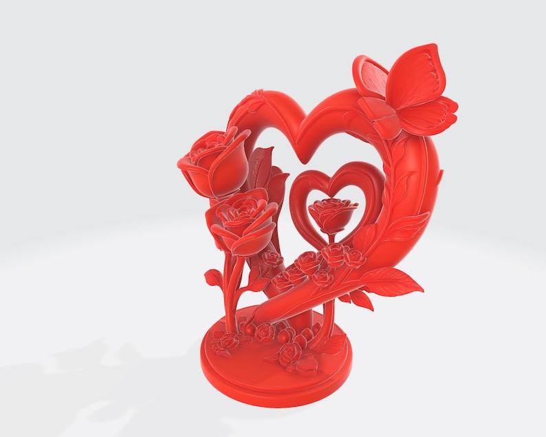 May include: A red decorative sculpture featuring a heart-shaped frame with a butterfly and roses. The sculpture has a round base and includes a smaller heart with a rose in the center. The roses are intricately detailed.