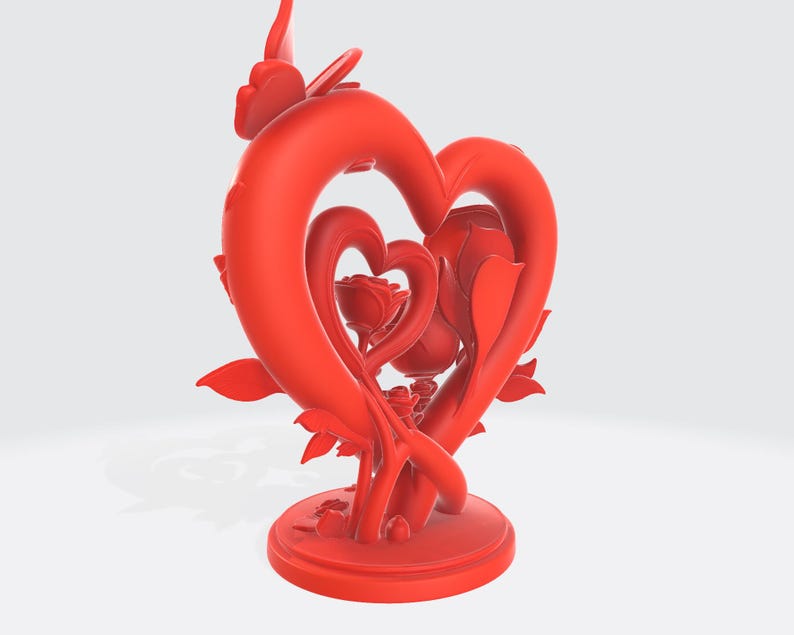 May include: A red sculpture featuring two intertwined hearts, with a rose at the center. The sculpture has a circular base and is adorned with leaves and floral details. The design is a romantic and decorative piece.