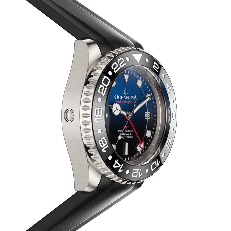 K&ouml;nnte beinhalten: Eine Oceaneva GMT Professional Automatic Uhr aus Edelstahl mit schwarzer L&uuml;nette und schwarzem Kautschukarmband. Das Zifferblatt ist blau mit wei&szlig;en und roten Akzenten. Die Uhr hat eine Datumsanzeige und ist wasserdicht bis 6000m.
