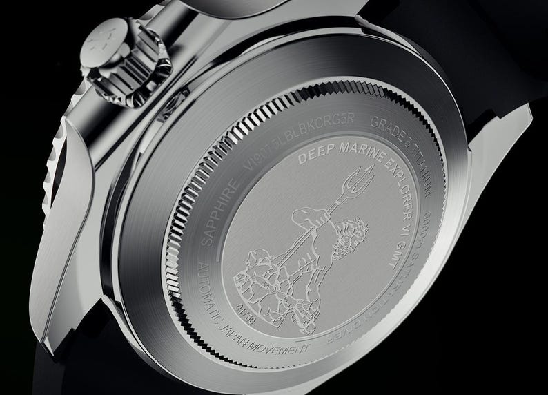 K&ouml;nnte beinhalten: Nahaufnahme des R&uuml;ckens einer silberfarbenen Uhr. Die Uhr hat eine detaillierte Gravur einer Figur mit einem Dreizack, die Worte "Deep Marine Explorer" und andere Texte. Die Uhr ist aus Titan und hat ein schwarzes Armband.