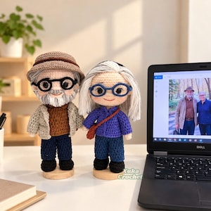 May include: Two handmade crochet dolls representing an older couple. The left doll wears a brown hat, beige jacket, brown shirt, and dark blue pants. The right doll has gray hair, a purple shirt, and blue pants. Both wear glasses and stand on wooden bases.