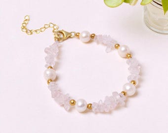 May include: A delicate bracelet featuring alternating white pearls, small gold beads, and light pink rose quartz chips. The bracelet has a gold-colored chain and clasp. The jewelry is displayed on a white surface.