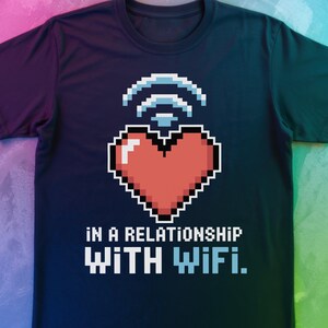 May include: Dark navy blue t-shirt featuring a pixelated heart and Wi-Fi symbol design. The text reads "IN A RELATIONSHIP WITH WIFI." The graphic is in white, red, and blue. A casual tee for tech enthusiasts.