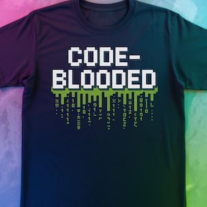 May include: Navy blue t-shirt featuring the text "CODE-BLOODED" in white block letters and a green pixelated design. Below the text are green pixelated characters that resemble binary code.