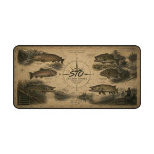 Op de afbeelding: Een rechthoekige bureaumat met een vintage-stijl sepia-illustratie van verschillende vissoorten, waaronder bruine forel en snoek. Het midden toont een kompasroos met de tekst STO LEGEND SERIES STRIKE TIDE OUTFITTERS.