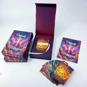 Puede incluir: Un juego de cartas de oráculo en una caja con un diseño de mariposa morada y rosa. El juego incluye una caja, un folleto y una baraja de cartas. La caja y el folleto presentan las palabras "Oraculo Milagros" y el nombre del autor. Las cartas están abanicadas.
