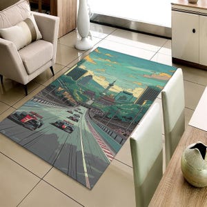 May include: A rectangular area rug featuring a race car track design with several race cars speeding along the track. The rug has a cityscape background with a blue and yellow sky. The rug is gray, red, and white.