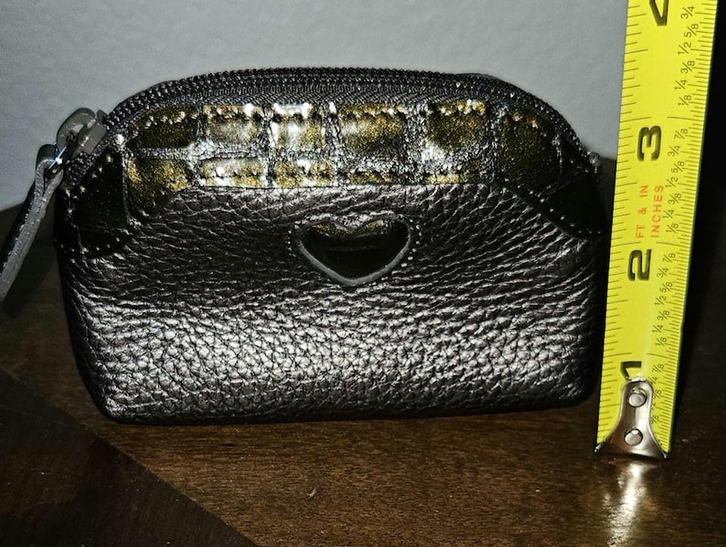 May include: A white ceramic mug with a black handle and the text "But First, Coffee" in a black, handwritten-style font. The mug is on a white surface.