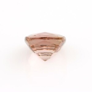 May include: A pink and white gemstone with a faceted cut. The gemstone is round and has a shiny finish.