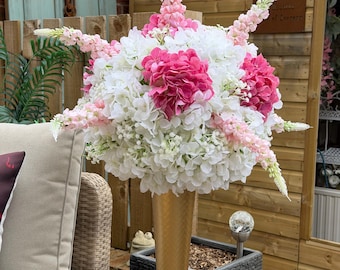 Elegante decoración de mesa en un gran jarrón de trompeta dorado.