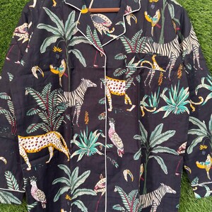 以下が含まれることがあります： 黒い持ち手と「But First, Coffee」の文字が黒い手書き風フォントで書かれた白いセラミックマグ。マグカップは白い表面に置かれています。