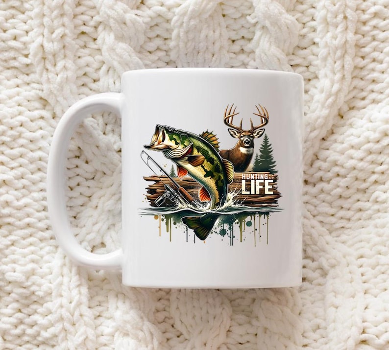 Może przedstawiać: Biały ceramiczny kubek z kolorową ilustracją skaczącego bass'a wielkogębowego, jelenia i napisem "HUNTING LIFE". Kubek ma biały uchwyt i jest umieszczony na teksturowanym białym tle.