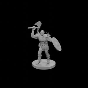 May include: A gray miniature figurine of a fantasy warrior, holding a battle axe overhead and a shield. The figure is on a circular base, with detailed armor and pouches. The background is black.