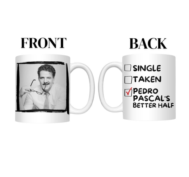 May include: A white ceramic mug with a black and white image of a man on the front. The back of the mug has a checklist with "Pedro Pascal's Better Half" checked. The mug has a white handle.
