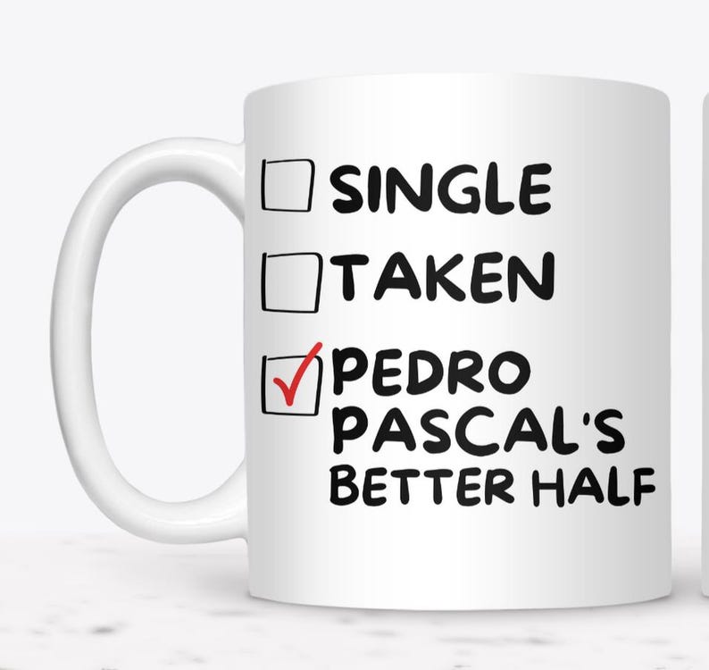 May include: White ceramic mug with the text "SINGLE", "TAKEN", and "PEDRO PASCAL'S BETTER HALF". The "PEDRO PASCAL'S BETTER HALF" option is checked with a red checkmark. The mug has a white handle.