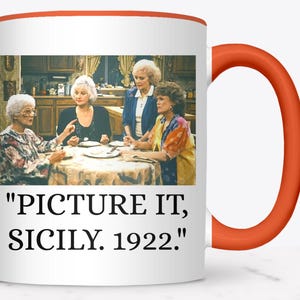 May include: White ceramic mug with an orange handle and rim. The mug features a colorful image of four women seated around a table. The text "PICTURE IT, SICILY. 1922." is printed below the image.