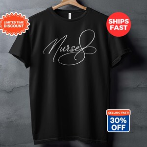 Könnte beinhalten: Schwarzes T-Shirt mit dem Wort "Nurse" in eleganter weißer Schrift. Das Shirt hängt an einem Holzbügel vor einem grau strukturierten Hintergrund. Enthält ein "Zeitlich begrenzter Rabatt" und "Schnell verkauft! 30% Rabatt" Badge.