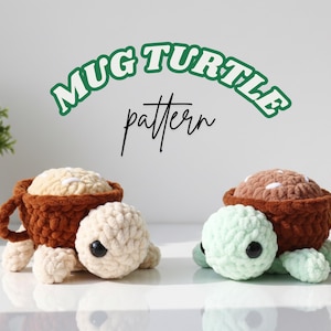 Pode incluir: Duas tartarugas de crochê, cada uma com uma concha em forma de caneca. Uma tartaruga tem uma concha marrom e uma cabeça e pés creme. A outra tem uma concha marrom e uma cabeça e pés verde claro. O texto "Mug Turtle pattern" está acima.