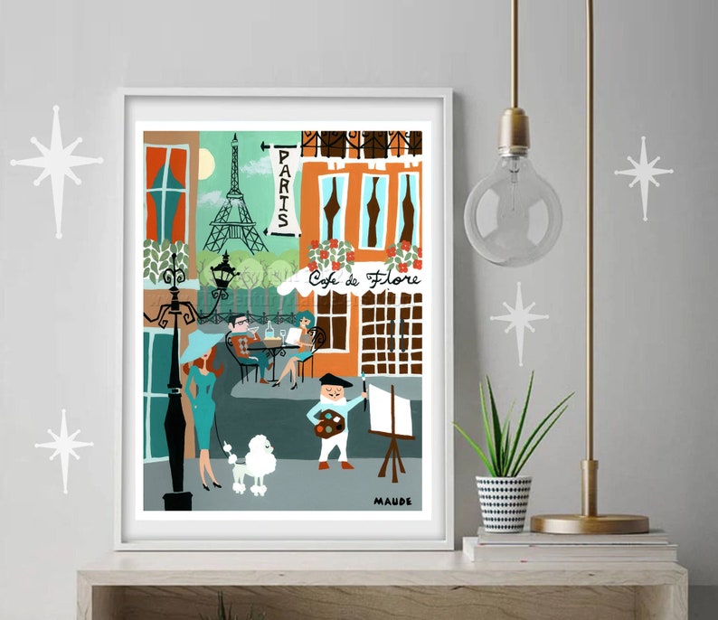 A poster art print of Paris in a retro mid-century modern style featuring a turquoise and burnt orange color scheme and framed in a white frame.