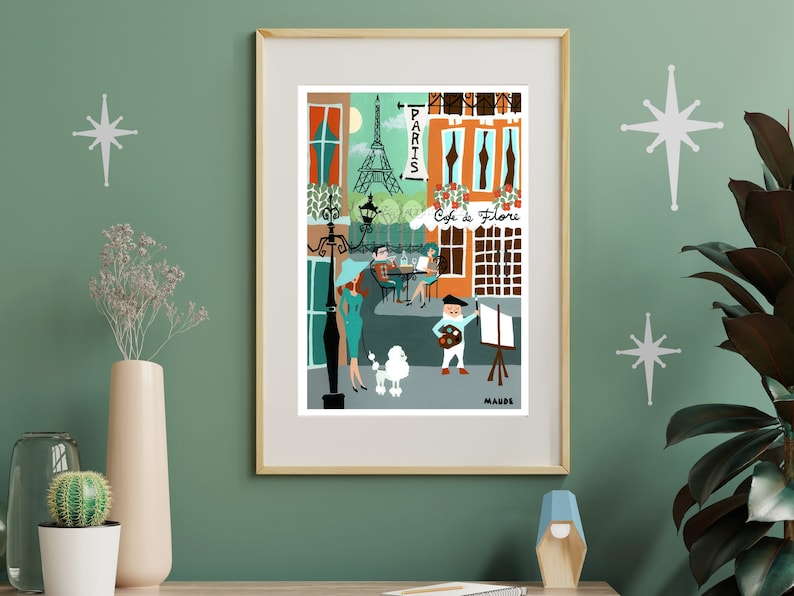 May include: A framed art print depicting a Parisian street scene with the Eiffel Tower, a cafe, and figures. The artwork features a palette of orange, teal, and brown, with the word "Paris" and "Cafe de Flore" visible.