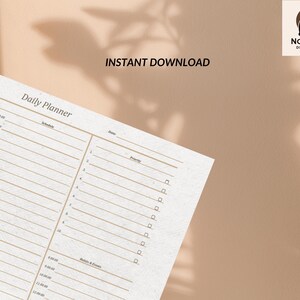 Puede incluir: Un planificador diario beige con secciones para horario, fecha y prioridad. Las palabras "Instant Download" están impresas encima del planificador. El fondo es de color beige liso con sombras.