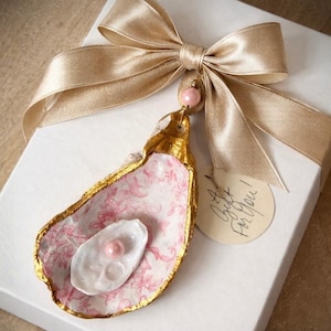 May include: A white ceramic mug with a black handle and the text "But First, Coffee" in a handwritten style. The mug is on a white surface. The mug is likely for hot beverages.