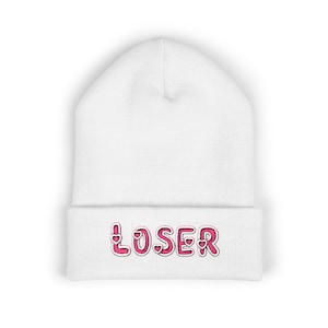 May include: A white beanie with the word "LOSER" embroidered in pink with heart accents. The beanie is made of a soft, knitted material and is suitable for cold weather. The text is in a playful, cartoon-like font.