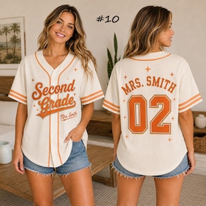 May include: A cream-coloured baseball jersey with orange trim, featuring the text "Second Grade" and "Mrs. Smith" on the front, and "MRS. SMITH" with the number "02" on the back, accented with small star graphics throughout the design.