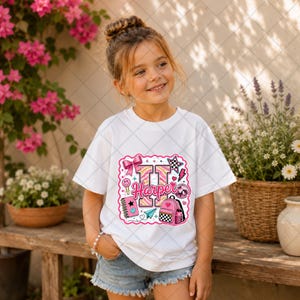 May include: A white short-sleeve t-shirt featuring a colourful graphic print of the letter H, the name Harper, a pink backpack, a bow, a disco ball, a notebook, and a paper airplane, all designed with pink, black, and white patterns.