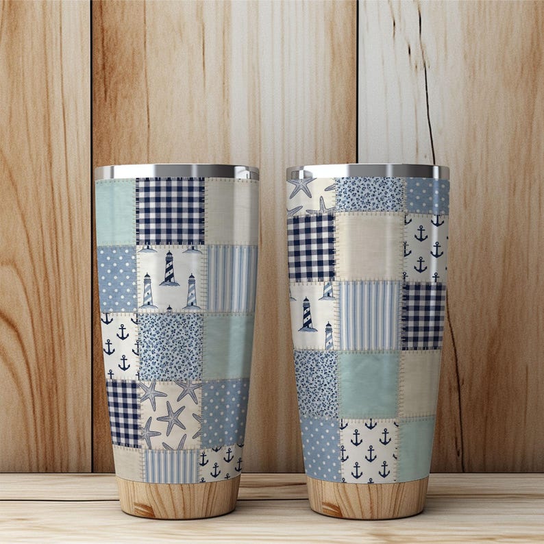 Puede incluir: Dos vasos aislados de acero inoxidable con un dise&ntilde;o de patchwork. El patchwork presenta varios patrones azules, incluyendo anclas, faros y estrellas de mar. La parte inferior de los vasos tiene un aspecto de vetas de madera.