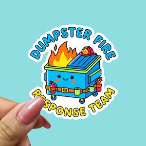 Puede incluir: Una pegatina troquelada que muestra un contenedor azul con cara sonriente, llamas naranjas y un casco de bombero rojo encima. El contenedor lleva un cinturón con extintores y tazas. El texto dice DUMPSTER FIRE RESPONSE TEAM.
