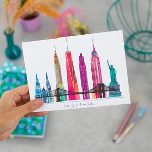 Puede incluir: Una ilustraci&oacute;n colorida del horizonte de la ciudad de Nueva York, con monumentos emblem&aacute;ticos como el Empire State Building, el Chrysler Building y la Estatua de la Libertad. El texto "New York, New York." est&aacute; escrito debajo de la ilustraci&oacute;n.