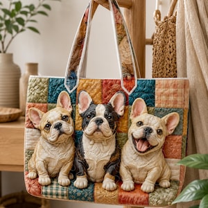 Op de afbeelding: Een gewatteerde draagtas met een patchworkontwerp in diverse aardetinten en patronen. De voorzijde toont drie driedimensionaal ogende Franse bulldogfiguren: twee reekleurige honden en een zwart-witte hond in het midden.