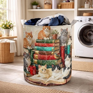 May include: A round laundry basket with a cat-themed design. The design features various cats sitting on stacks of books. The books are in shades of red, green, and brown. The cats have orange, grey, and black and white fur.