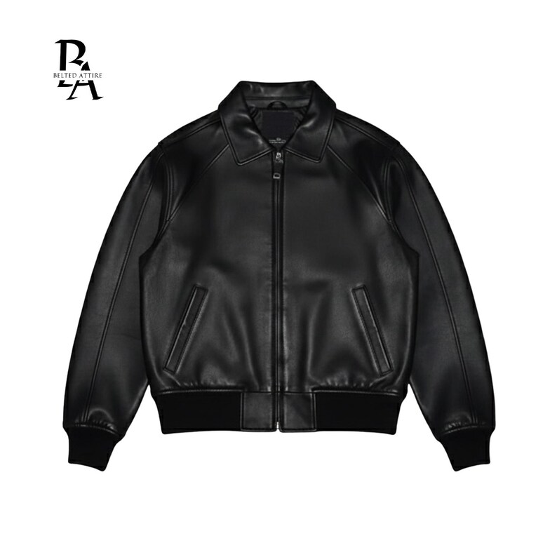 May include: A black leather jacket with a collared neckline and a zipper closure. The jacket features two front pockets and ribbed cuffs and hem. The brand logo "BELTED ATTIRE" is in the top left corner.