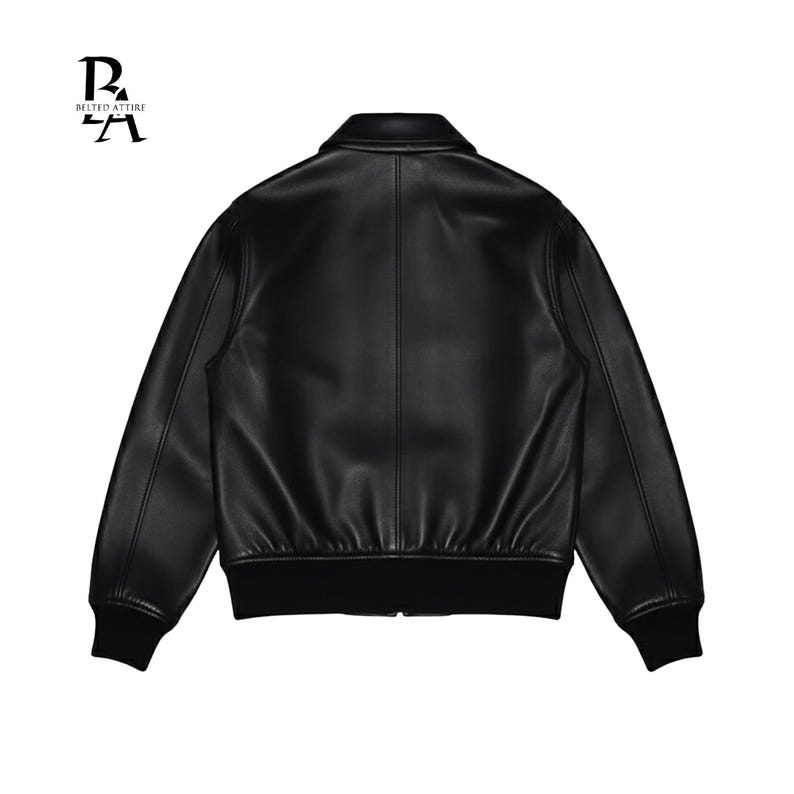 May include: A black leather jacket with a classic bomber style. The jacket features a collared neckline, long sleeves with ribbed cuffs, and a ribbed hem. The back view showcases the jacket's smooth, sleek texture and design. The brand logo is visible in the upper left corner.