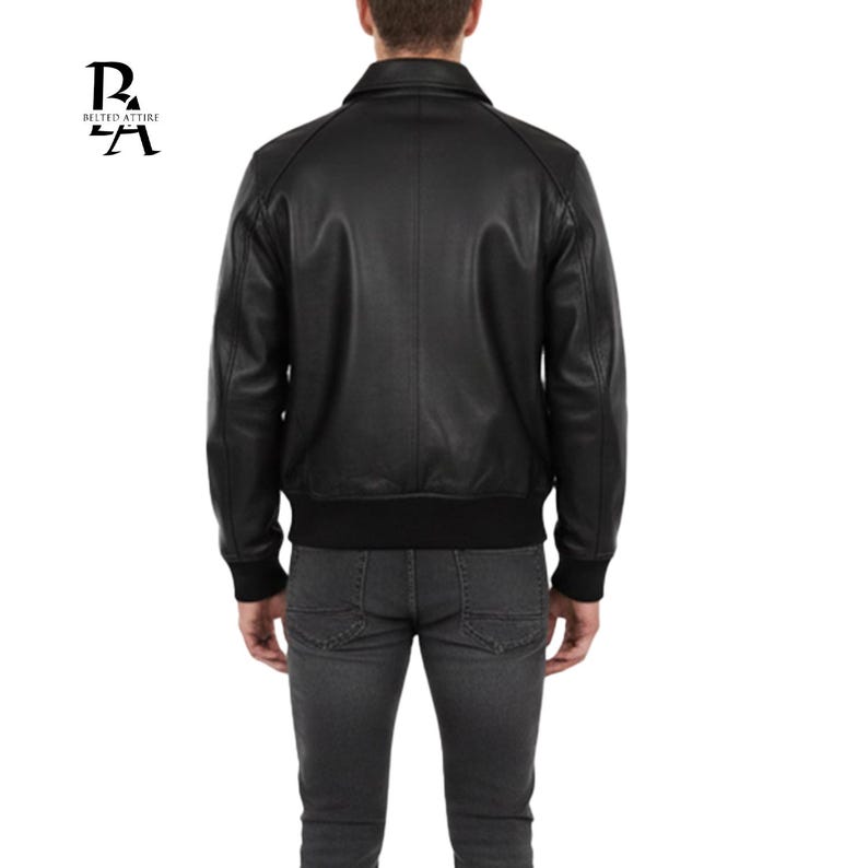 May include: Black leather jacket with a classic collar, ribbed cuffs, and a ribbed hem. The jacket has a simple, streamlined design. The logo "BELTED ATTIRE" is in the upper left corner.