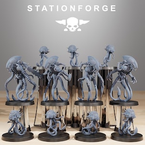 May include: A selection of grey alien-like figurines with multiple tentacles and bulbous heads. The figurines are displayed on black circular stands. The word "STATIONFORGE" is printed at the top of the image, along with a skull and wings logo.