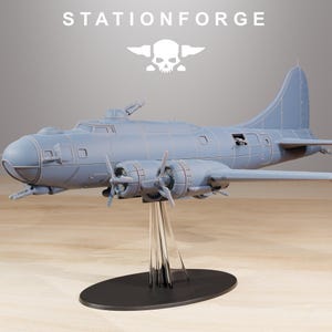 May include: A light gray model airplane with four propellers, mounted on a clear stand with a black base. The model has detailed features, including windows and a tail fin. The text "STATIONFORGE" and a skull logo are visible.