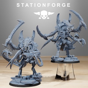 Puede incluir: Dos figuras en miniatura grises y detalladas de criaturas alienígenas con garras y cuchillas afiladas. Las figuras están sobre bases, una sobre un soporte transparente. El texto "STATIONFORGE" y un logotipo de calavera están en la parte superior.