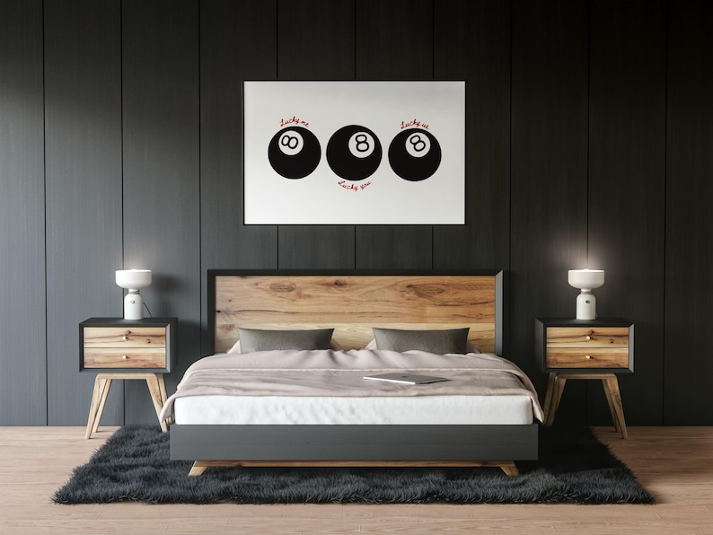 Pode incluir: Um quarto moderno com uma cama, cabeceira de madeira, duas mesinhas de cabeceira com candeeiros e um tapete preto. Acima da cama, uma obra de arte emoldurada com tr&ecirc;s bolas de bilhar pretas e as palavras "Lucky me" e "Lucky you".