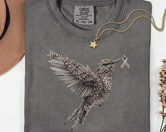 Camiseta unisex Comfort Colors® para la concienciación sobre el glioblastoma, con lazo gris y colibrí enjoyado, apoyo para personas con cáncer cerebral, regalo para supervivientes de tumores cerebrales.