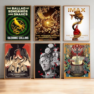 Puede incluir: Seis pósteres enmarcados de The Hunger Games: The Ballad of Songbirds and Snakes. La colección presenta varios diseños artísticos que incluyen un pájaro amarillo, serpientes doradas, una mano sosteniendo una serpiente y una rosa, y retratos.