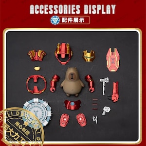 May include: A selection of Iron Man-themed accessories and a capybara figurine are arranged on a dark surface. The accessories are red and gold, including a helmet, chest piece, and arm pieces. The text "ACCESSORIES DISPLAY" is at the top.