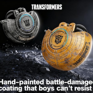 Puede incluir: Dos objetos con temática Transformers dañados en batalla. Uno es plateado, el otro es amarillo. Cada uno tiene un diseño circular con el logotipo y el texto de Transformers. El texto "TRANSFORMERS" es visible en ambos objetos. La imagen también incluye el texto "Hand-painted battle-damaged coating that boys can't resist."