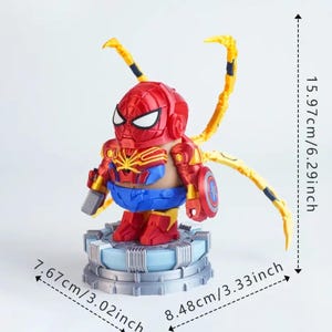 May include: A red, blue, and gold Spider-Man action figure with yellow appendages. The figure is 6.29 inches tall, 3.02 inches wide, and 3.33 inches deep. It stands on a silver and blue base and holds a gray tool and a shield.