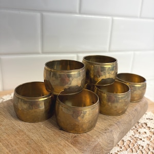 May include: A set of three ceramic mugs with a speckled, matte finish. The mugs are in shades of cream, light gray, and dark gray. Each mug has a simple, minimalist design and a rounded handle.