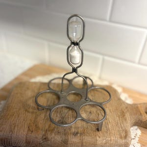 May include: A handmade wooden sign with the text "Welcome" in a playful font. The sign features a distressed white background and a dark brown frame, perfect for a front door or entryway. The sign measures approximately 12 inches wide.